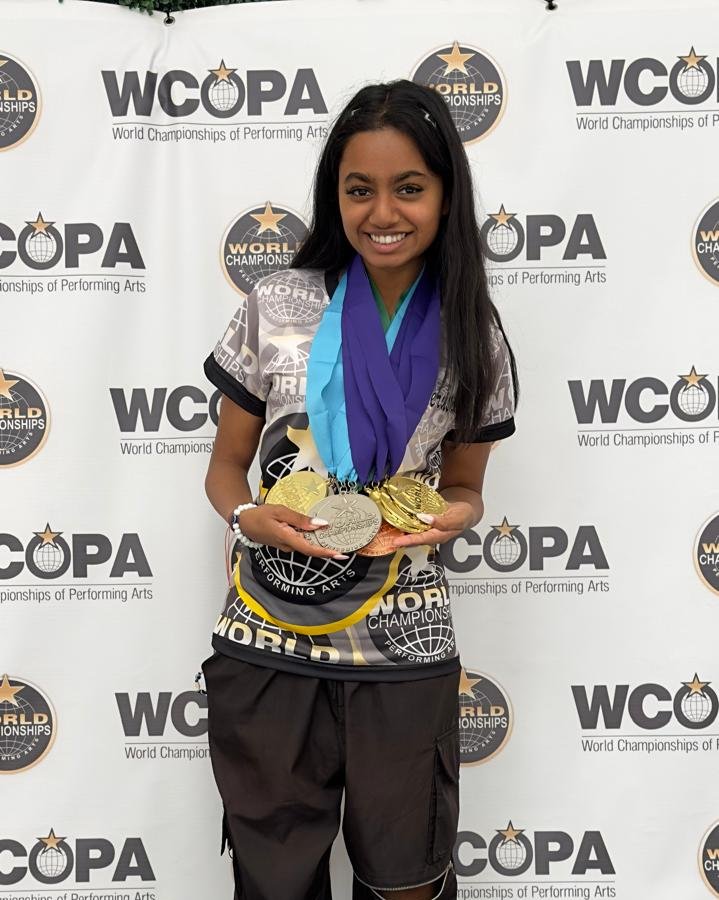 Jerusha holding medals at WCOPA, representing UAE